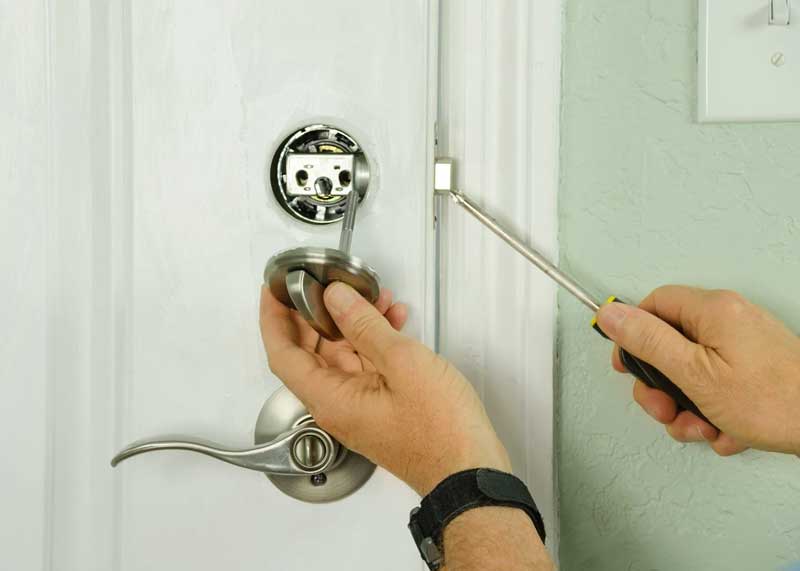 Locksmith removing thumb turn lock on door