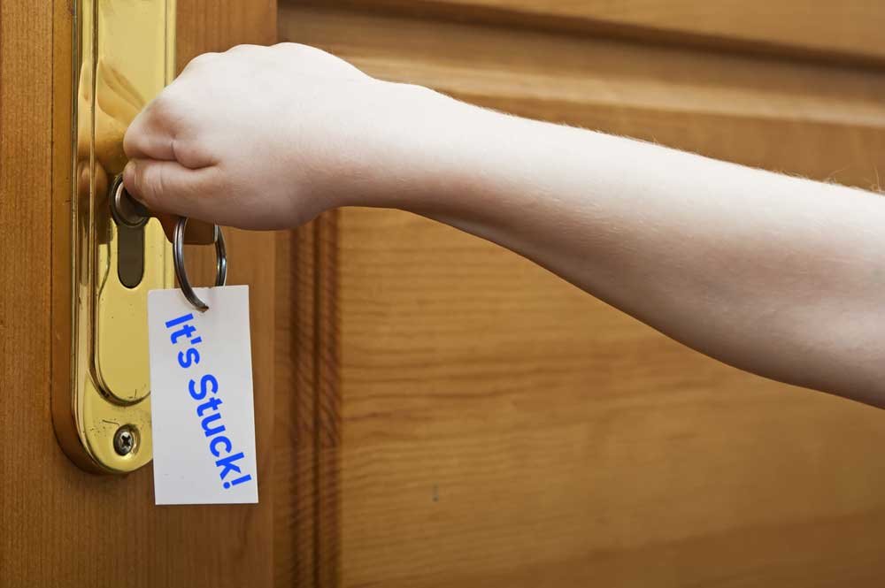 Door handle, key, and key tag labelled "it's Stuck"