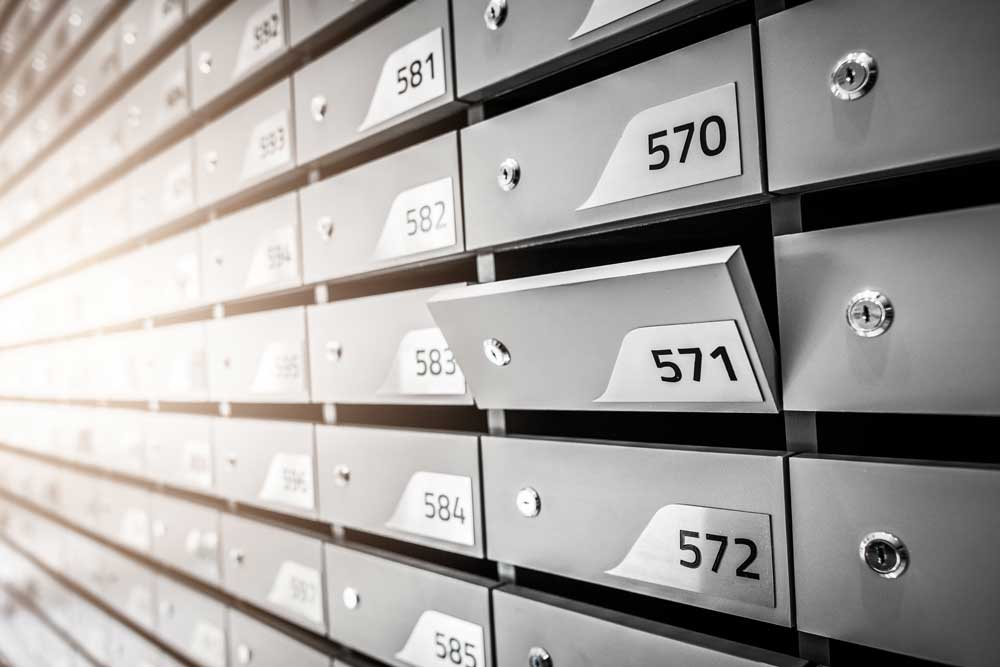 Letter box opening in a wall of numbered mailboxes